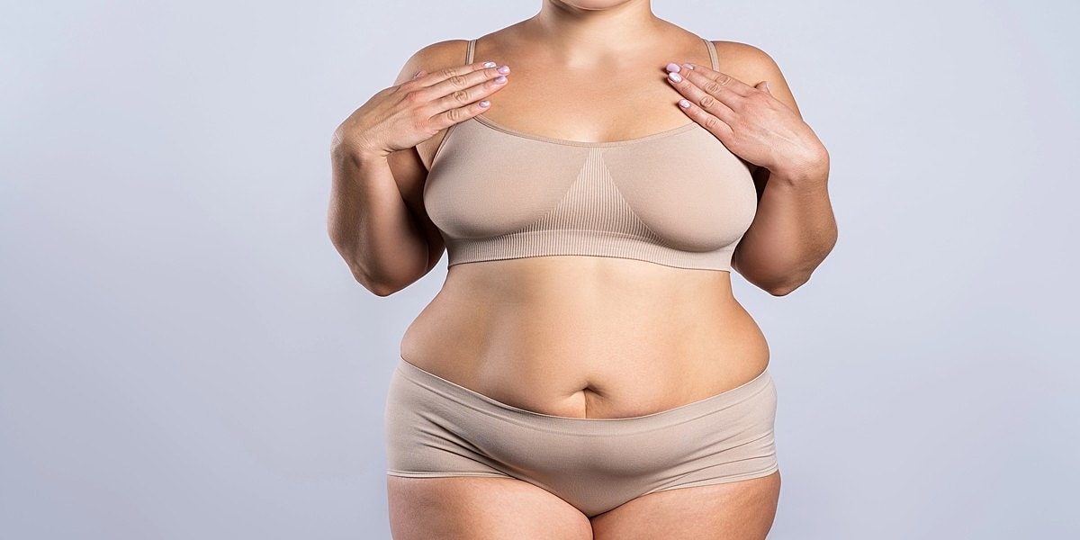 Model wearing beige lingerie set, hands on hips.