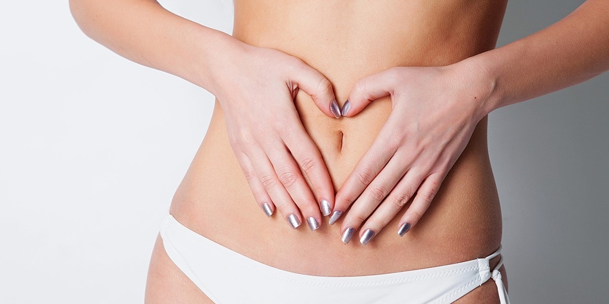 Hands forming heart shape on abdomen.