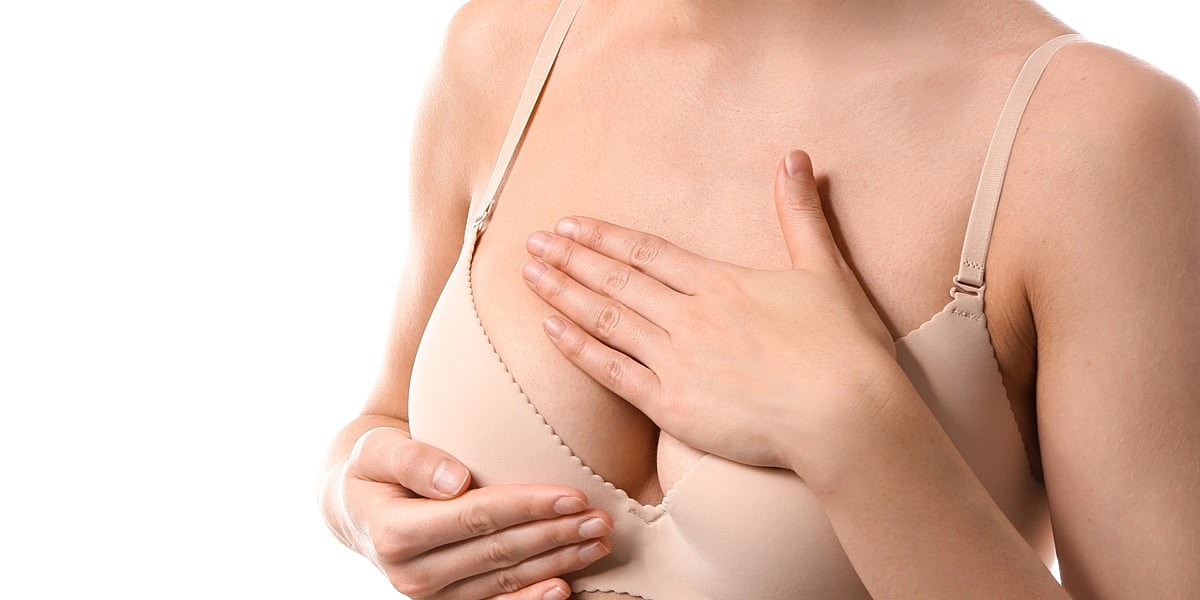 Woman adjusting her bra with one hand.