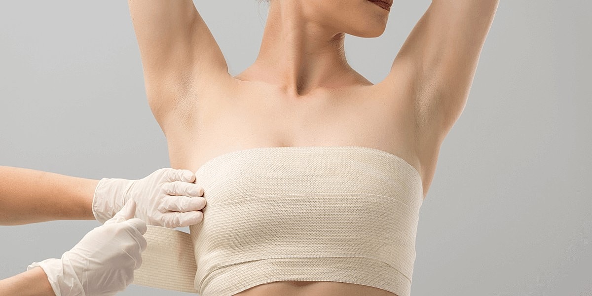 Medical professional applying bandage on patient's torso.