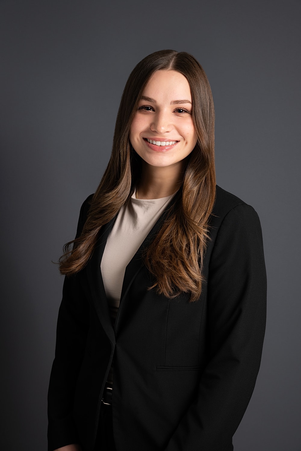 Professional portrait of smiling woman in suit.